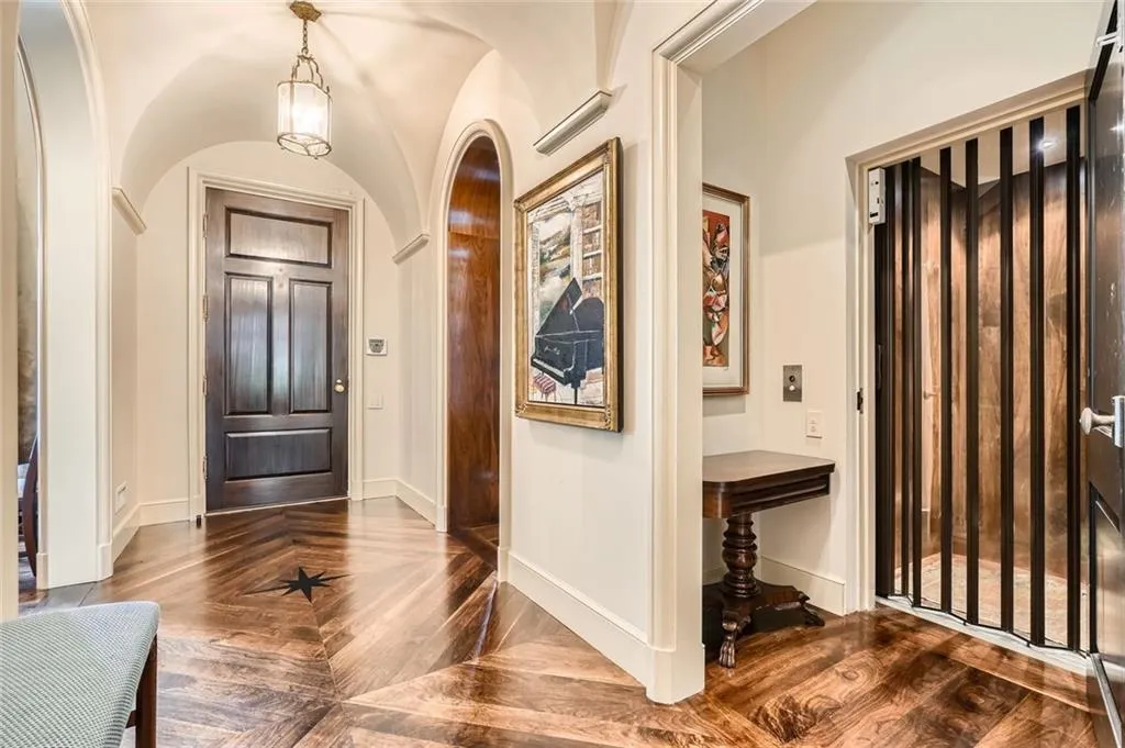 Entry hall is detailed with arched ceilings.  There is a large elevator that stops at all four levels.The floor is walnut with "star' insets.  The walnut flooring is throughout the top three floors.  There is stone flooring on the terrace leve.