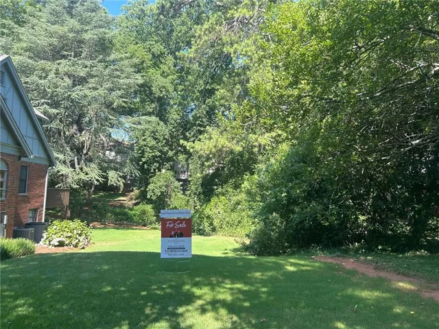 View of grassy yard with view of scattered trees