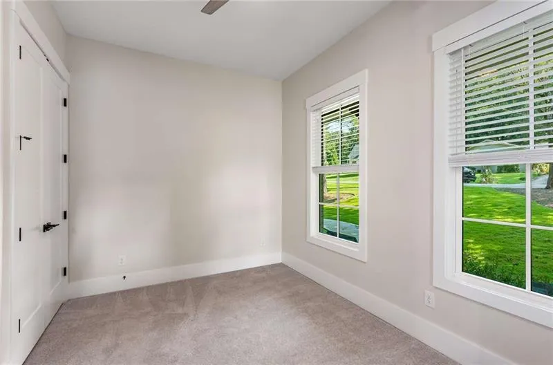 Unfurnished room with light colored carpet and ceiling fan