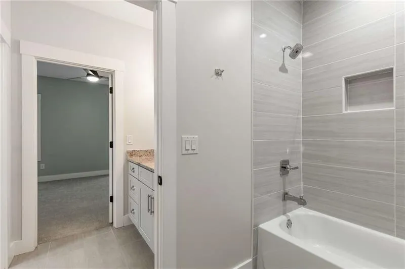 Bathroom with shower / bathtub combination, vanity, light tile patterned floors, and light carpet