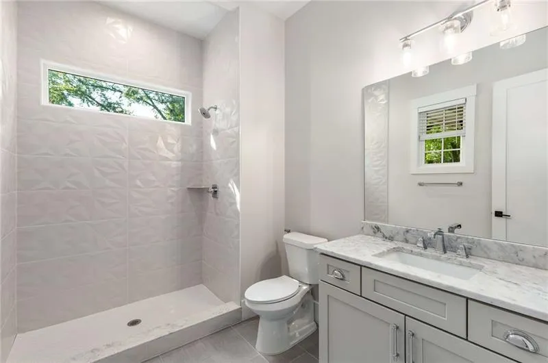 Full bath featuring vanity, a stall shower, and light tile patterned flooring