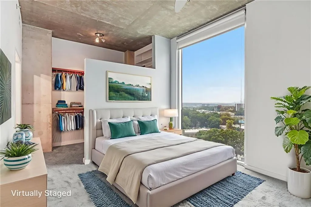 Primary bedroom with a custom walk in closet and direct view of Downtown skyline