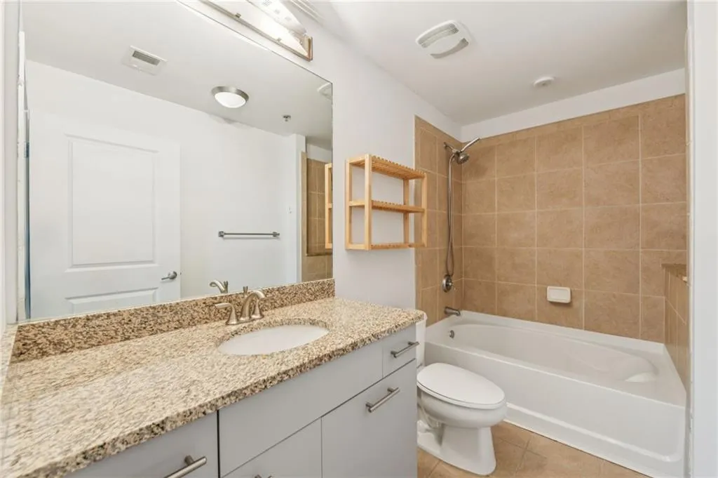 Full bath featuring vanity, tub/shower combo, and tile floors
