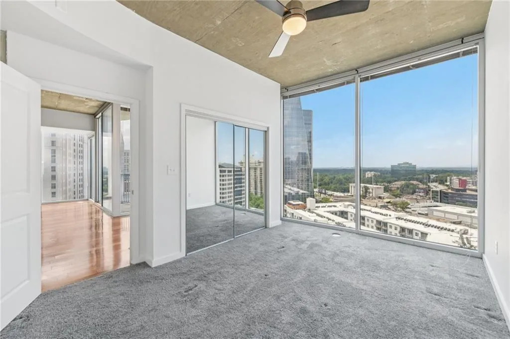 Unfurnished bedroom featuring a city view,  and ceiling fan