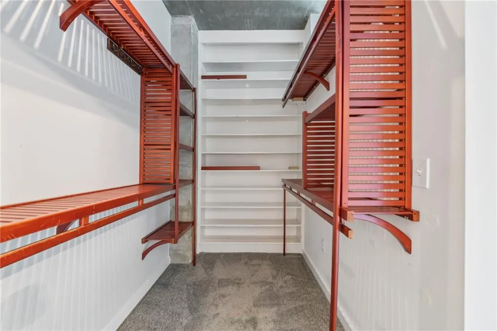 Walk in closet featuring custom wood shelving
