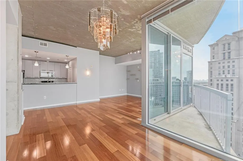 Unfurnished dining room with a chandelier, wood finished floors, and expansive windows