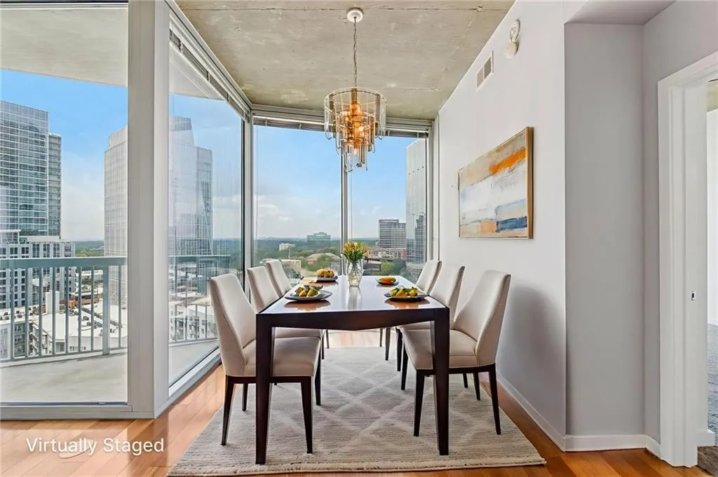 Dining area featuring  wood finished floors, a view of city, a chandelier, and floor to ceiling windows