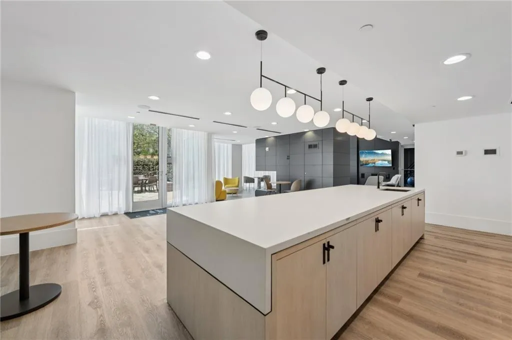 Kitchen area in clubroom featuring a spacious island and pendant lighting