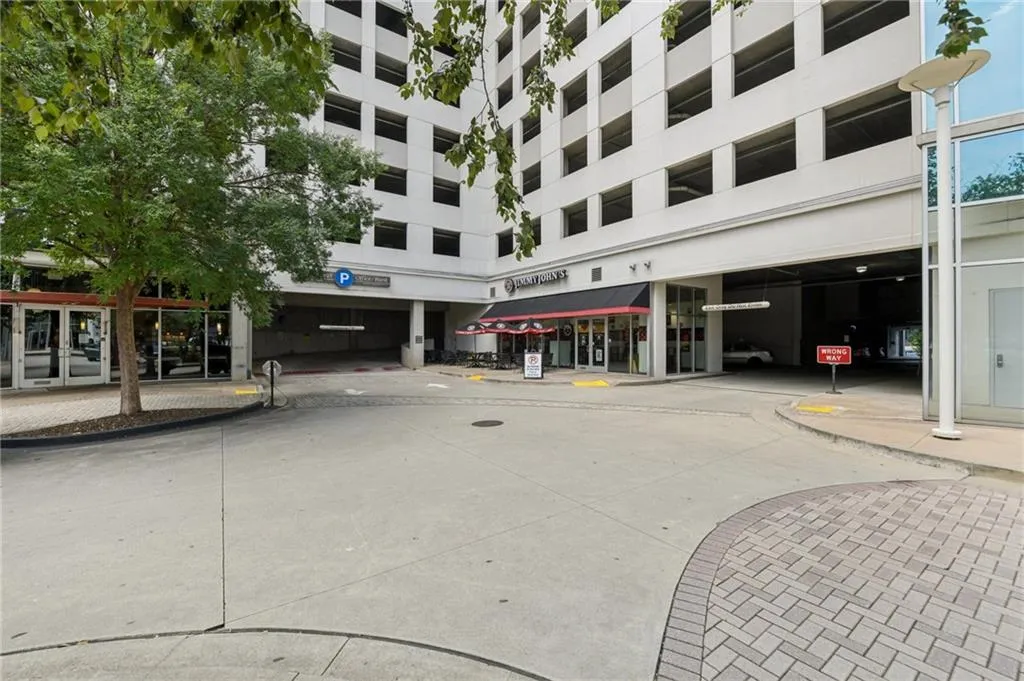 Front of building with retail/restaurants and parking deck entrance