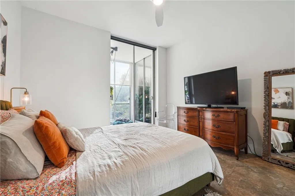 Bedroom with access to exterior, ceiling fan, and expansive windows