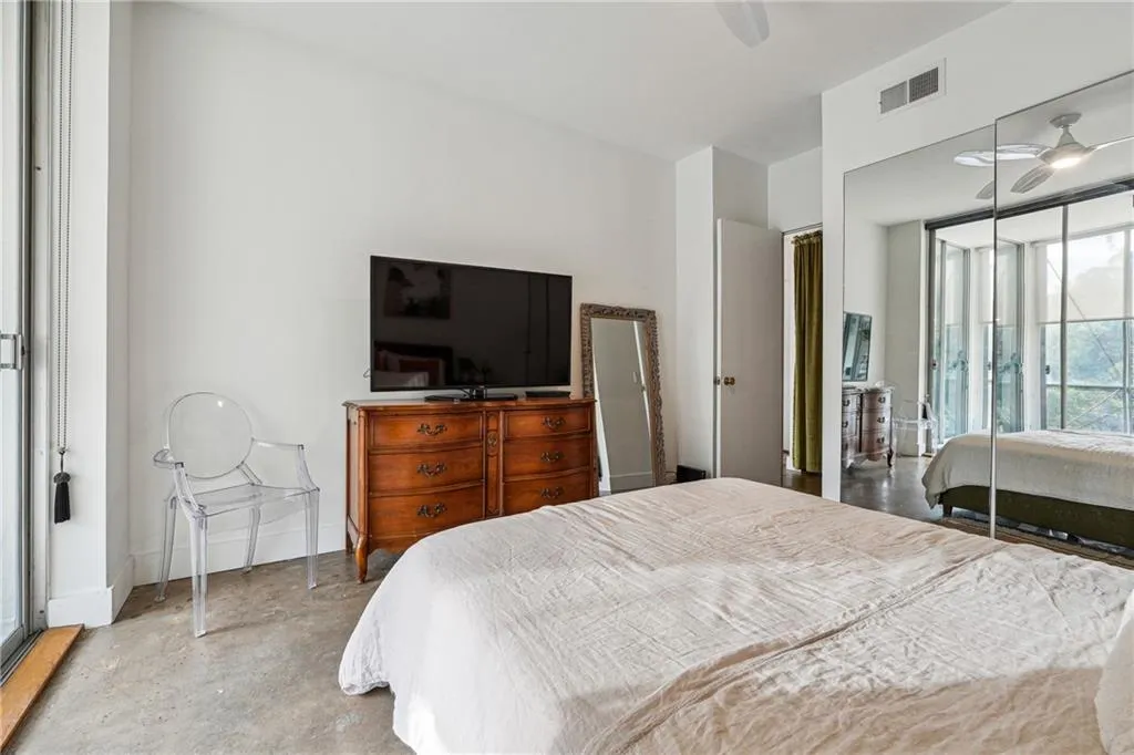 Bedroom featuring unfinished concrete floors, a closet, and a ceiling fan