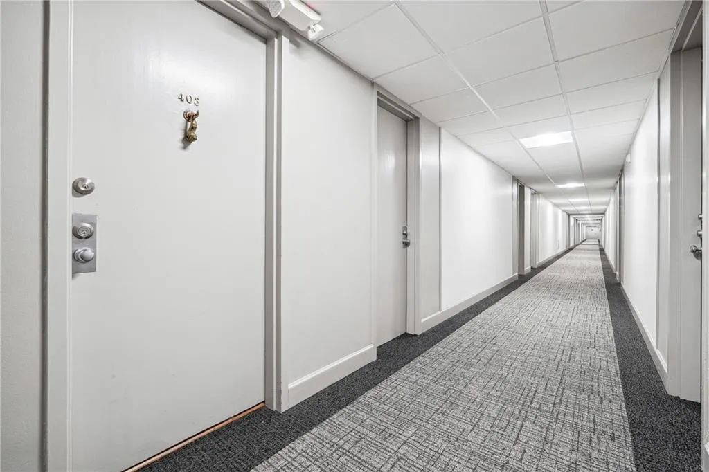 Corridor with dark carpet and a paneled ceiling