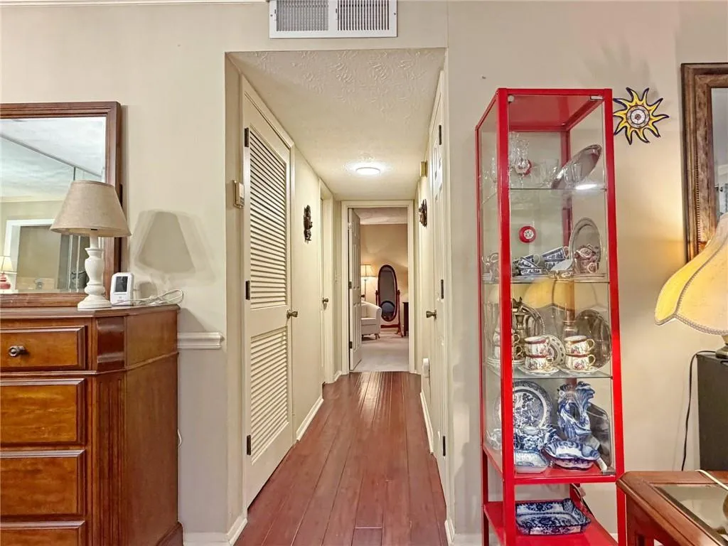 Hallway featuring a textured ceiling and dark wood-type flooring