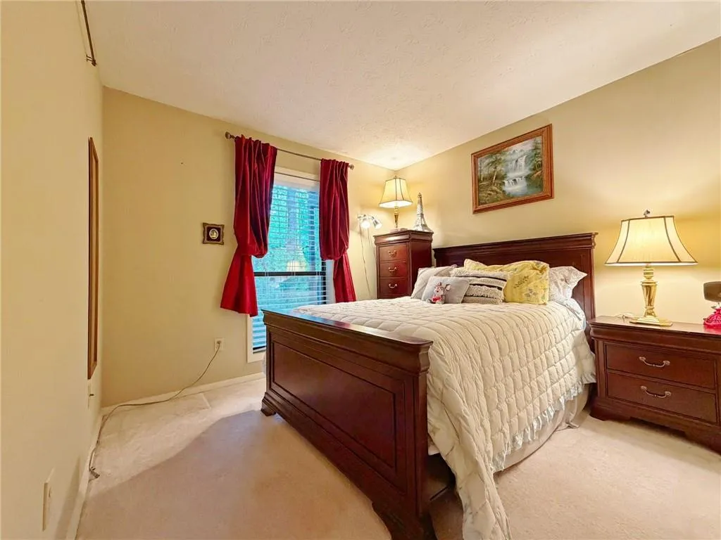 Bedroom featuring light colored carpet and a textured ceiling