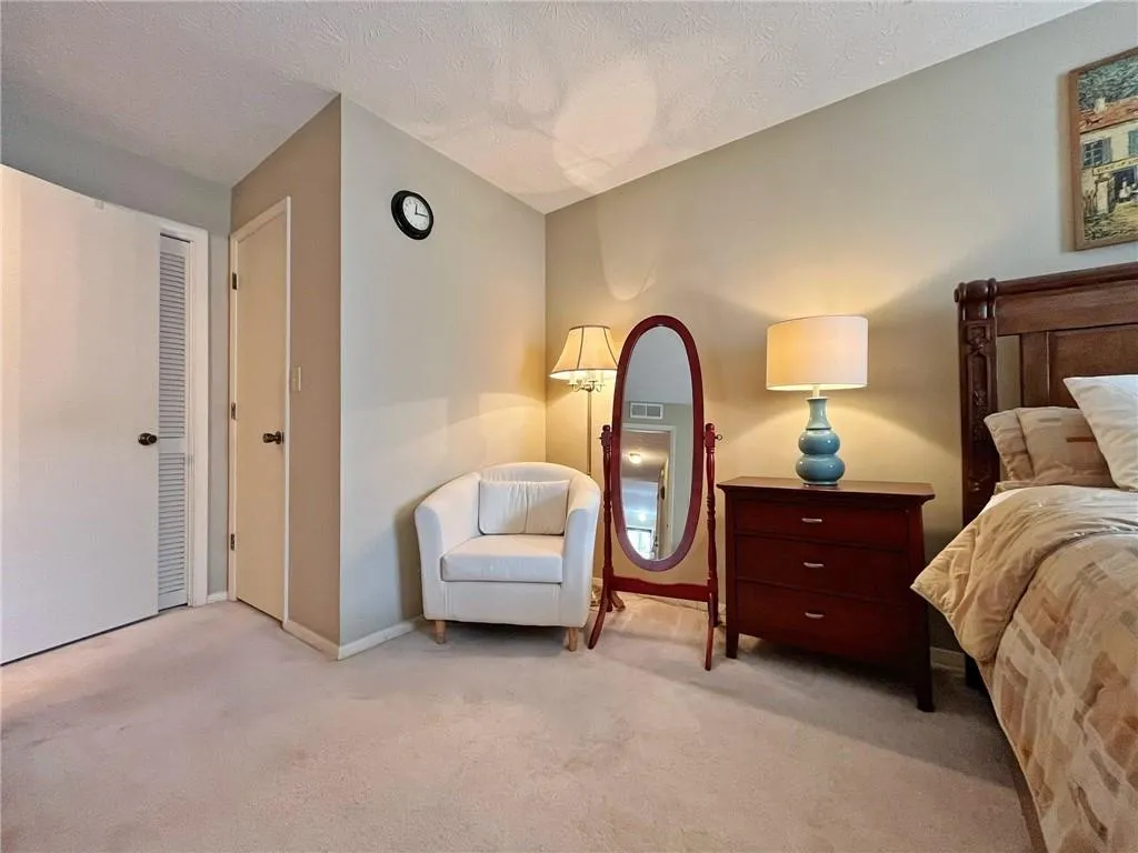 Bedroom featuring light colored carpet and a textured ceiling