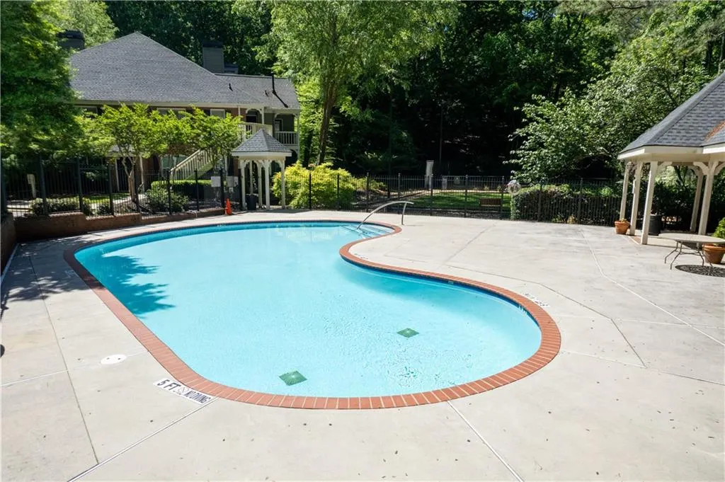 The sparkling community pool features a gazebo, patio area & fencing.