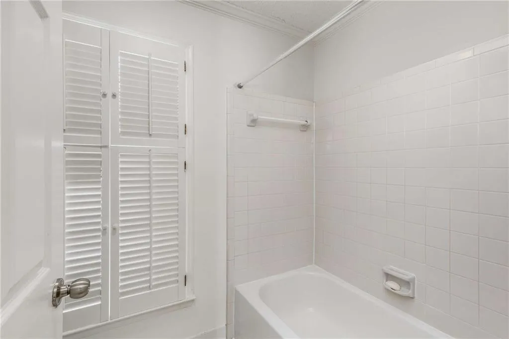 The updated primary en suite tub/shower combination in bright white.