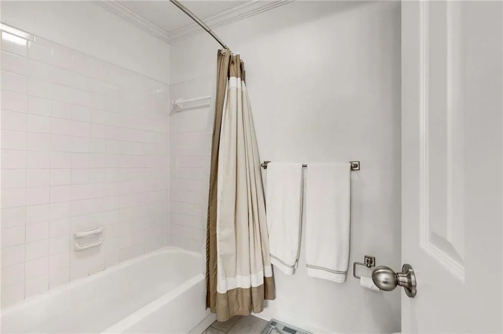 The guest bathroom features a tub/shower combination in bright white.