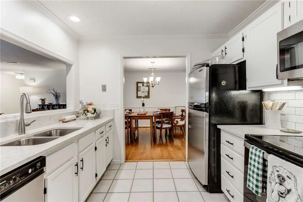 The updated gourmet kitchen features gleaming stainless steel appliances & pristine quartz counters that compliment a brick patterned tile backsplash.
