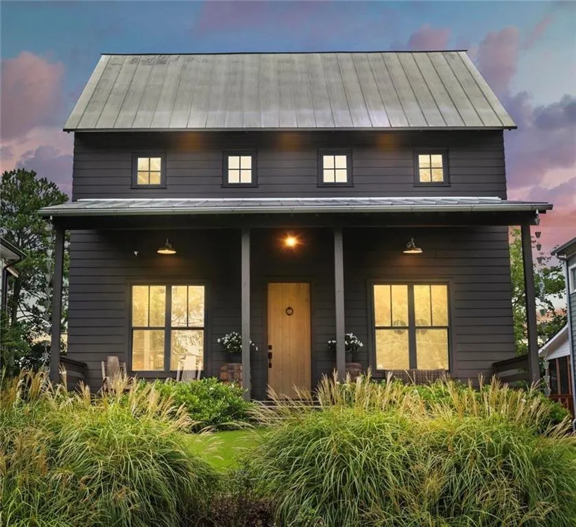 View of front of home with a standing seam roof, a porch, and a metal roof