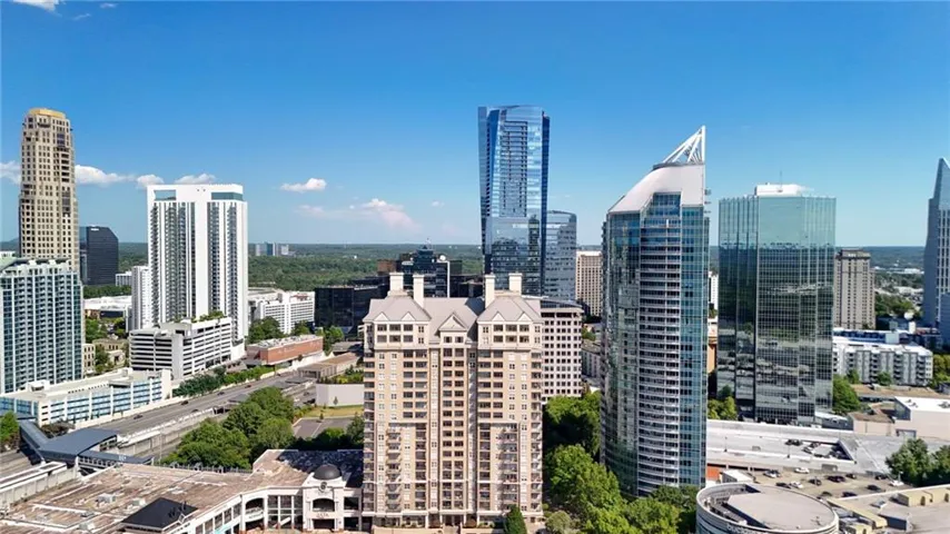 Expansive urban skyline with diverse architectural styles, featuring multiple high-rise buildings and a clear blue sky