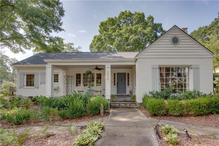 White brick exterior with gray siding accents, stone step entry, and a covered porch