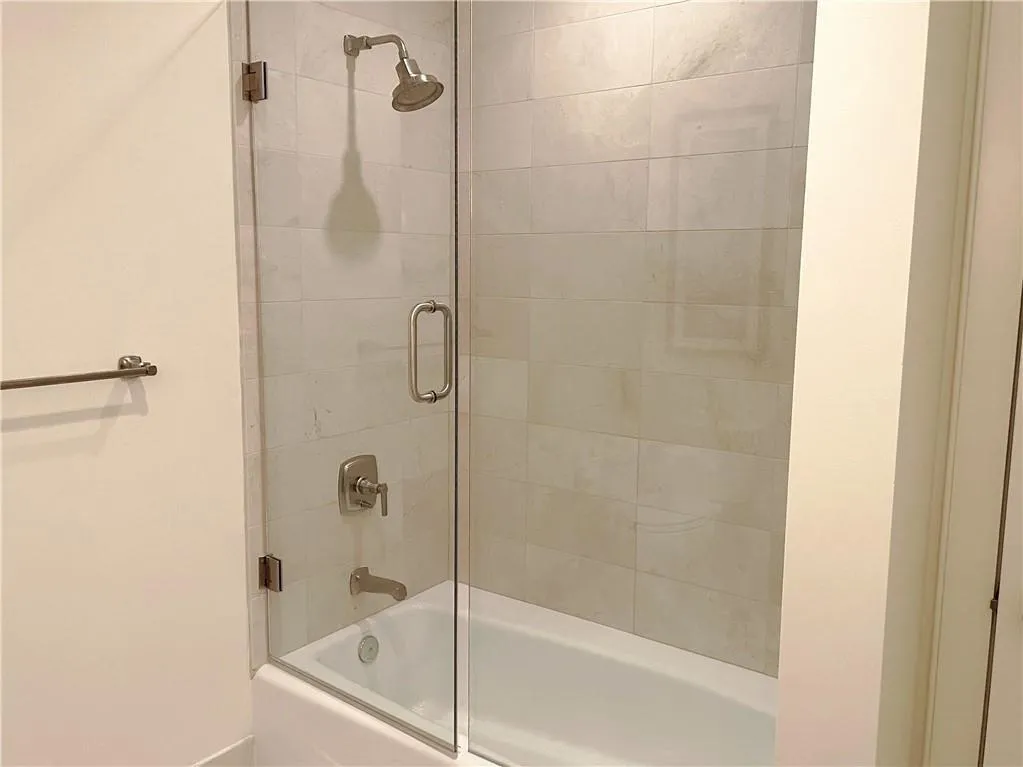 Secondary Bathroom featuring shower / Tub combination with glass door enclosure