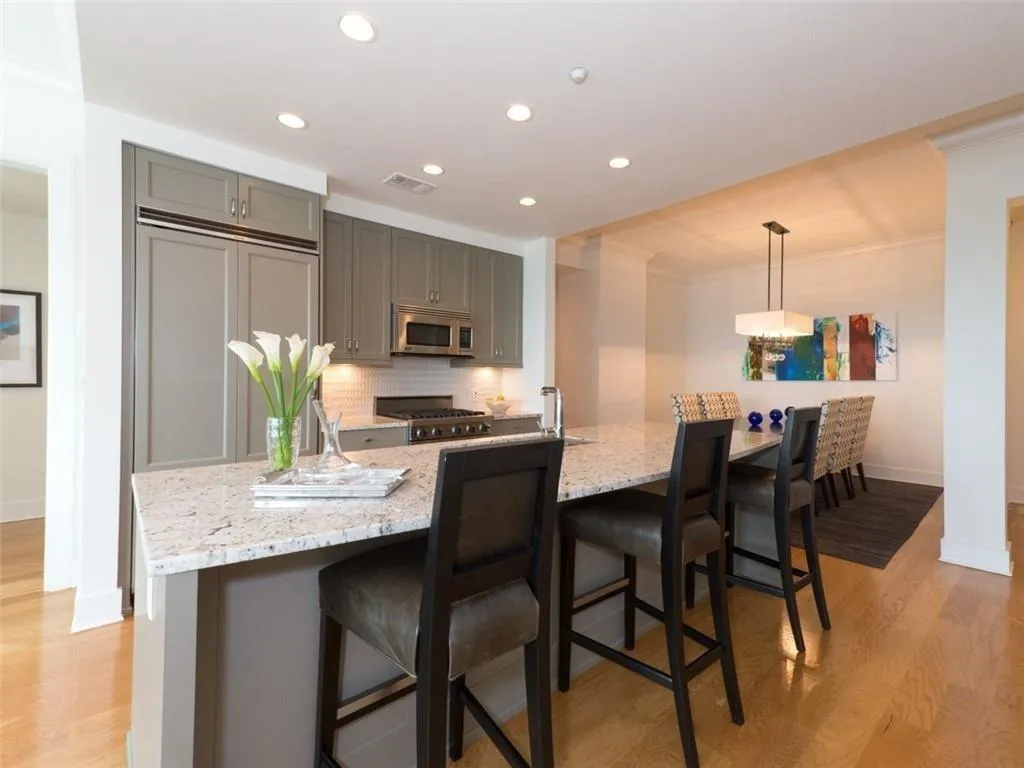 Kitchen with hard wood flooring, stainless steel  Appliances, and Stone Countertops