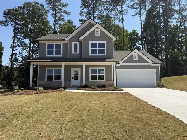 Two-story residence featuring a covered front porch with white columns, a two-car garage, and gray siding with brick accents