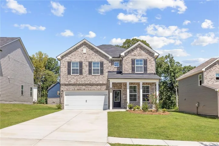 Brick and siding exterior with a covered entry, two-car garage, manicured lawn, and concrete driveway