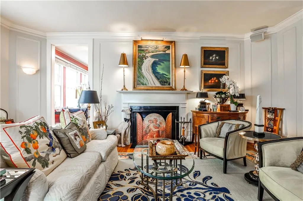 Living area with ornamental molding, wood finished floors, a high end fireplace, and a decorative wall