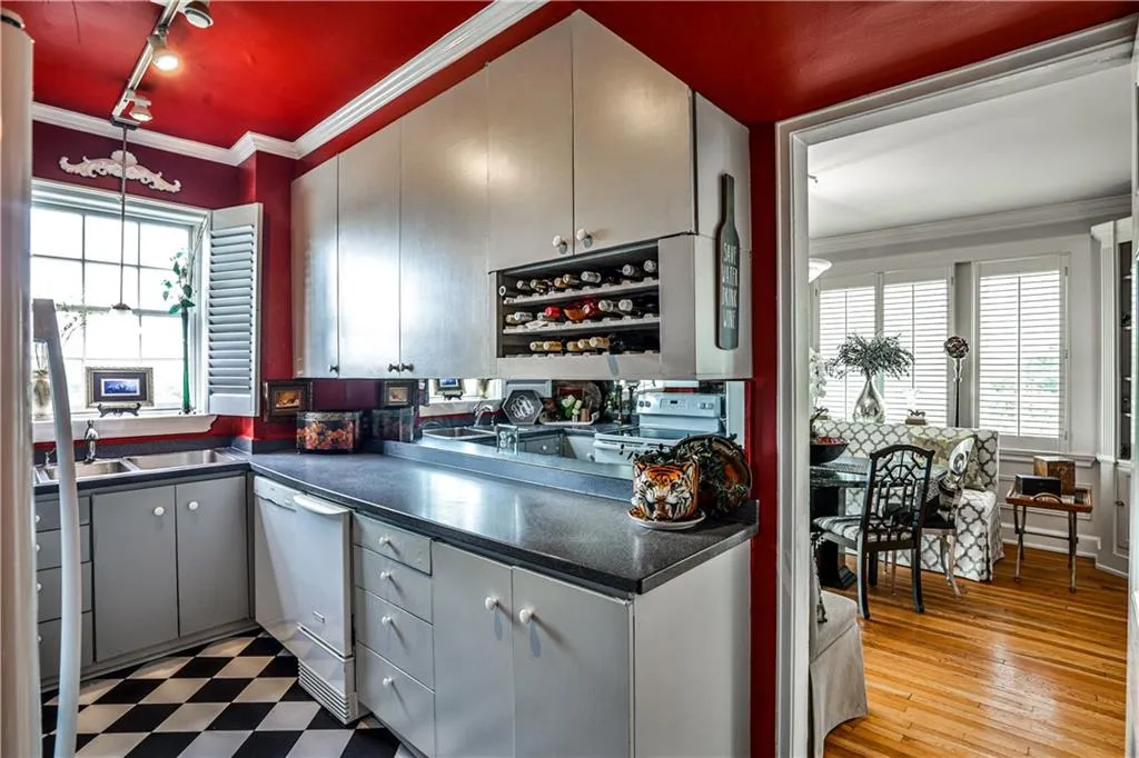 Kitchen featuring crown molding, dark countertops, gray cabinetry, rail lighting, and white appliances