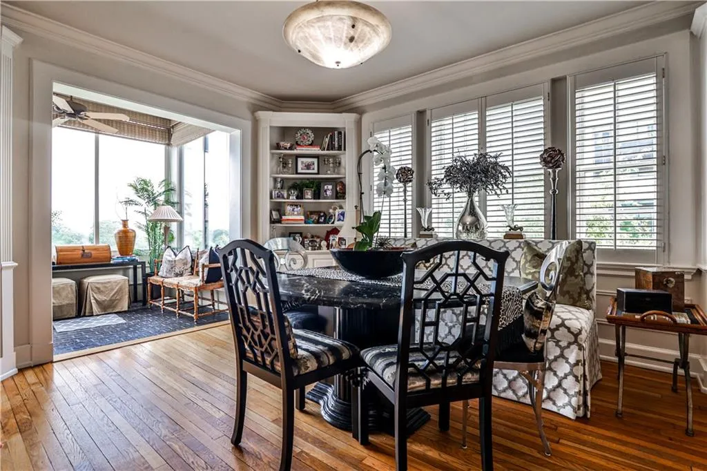 Dining space with crown molding and wood-type flooring