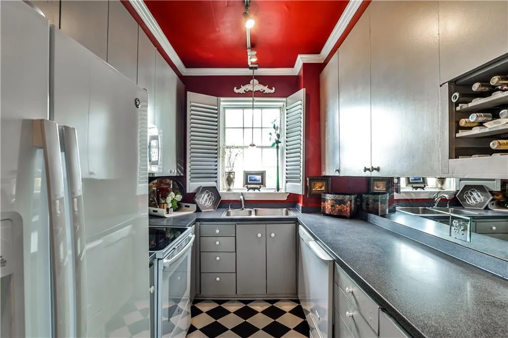Kitchen with white appliances, dark countertops, ornamental molding, tile patterned floors, and gray cabinets