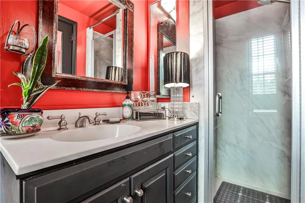 Bathroom featuring a marble finish shower and double vanity