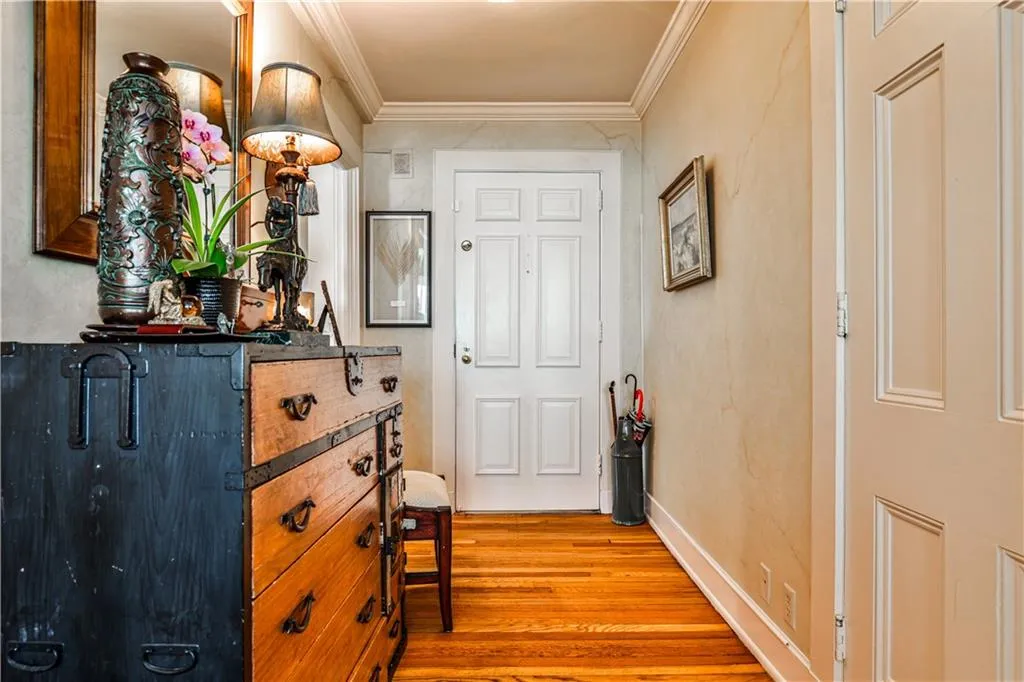 Corridor featuring light wood-style floors and ornamental molding