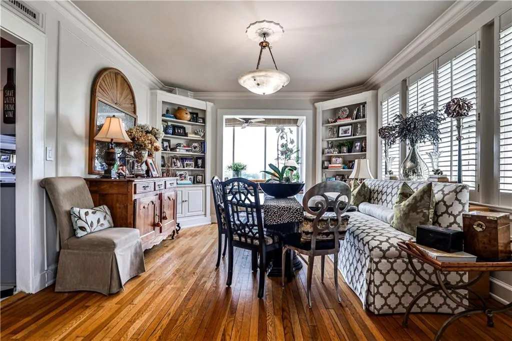 Dining space with light wood-style flooring, crown molding, and built in features