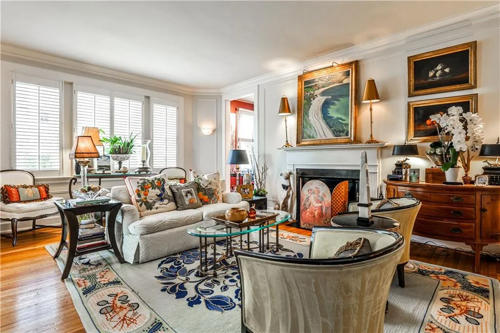 Living room featuring ornamental molding, wood finished floors, and a fireplace with flush hearth