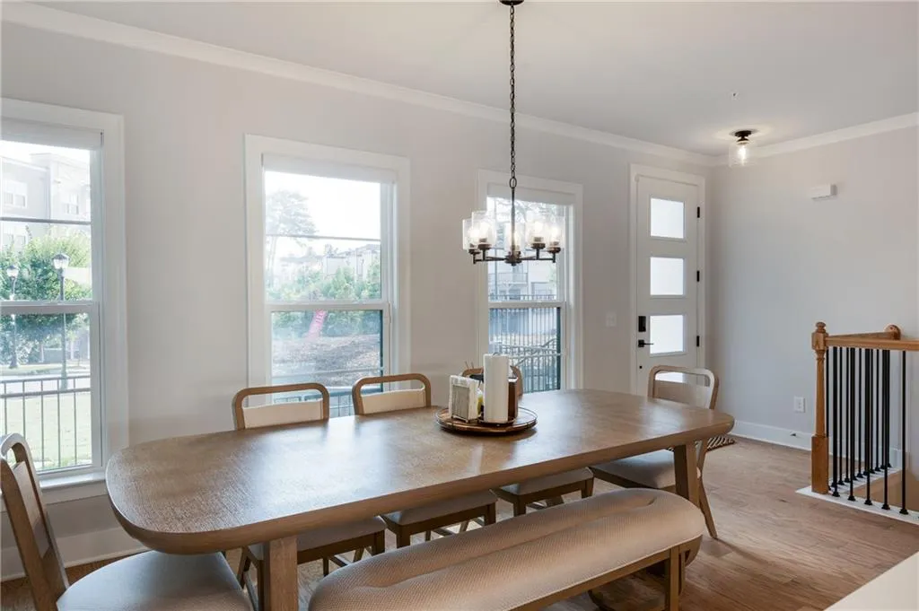 Dining space featuring crown molding, light wood finished floors, plenty of natural light, and a chandelier