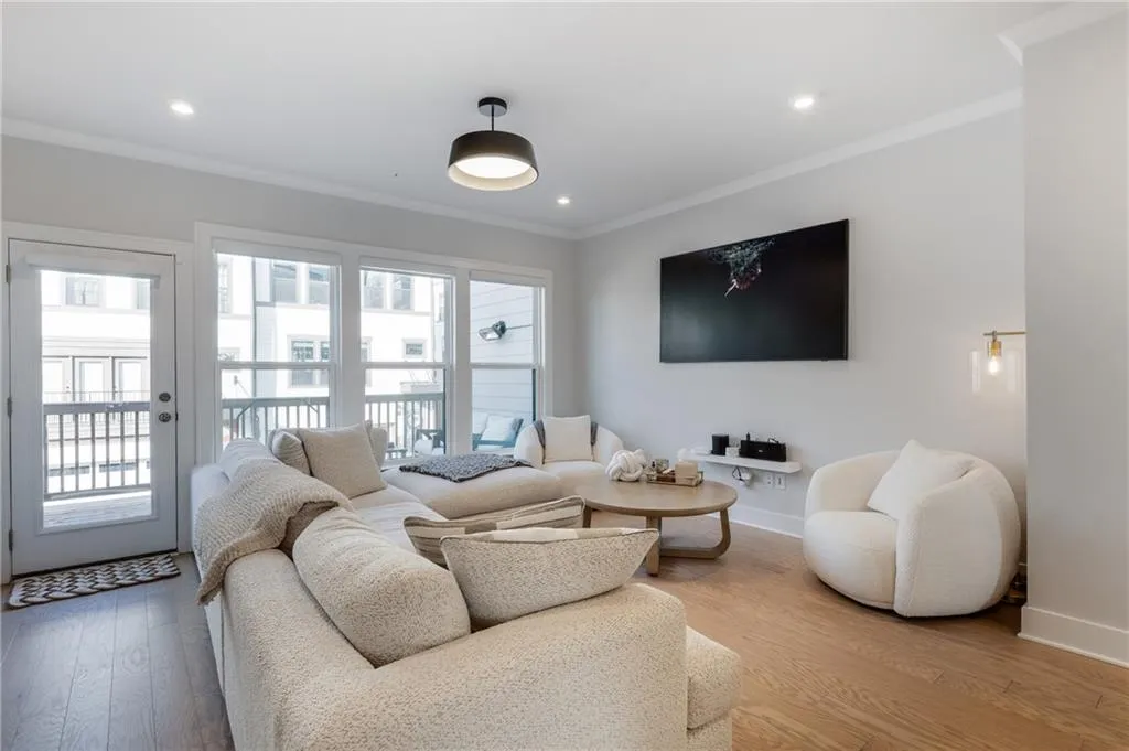 Living room with crown molding, wood finished floors, and recessed lighting