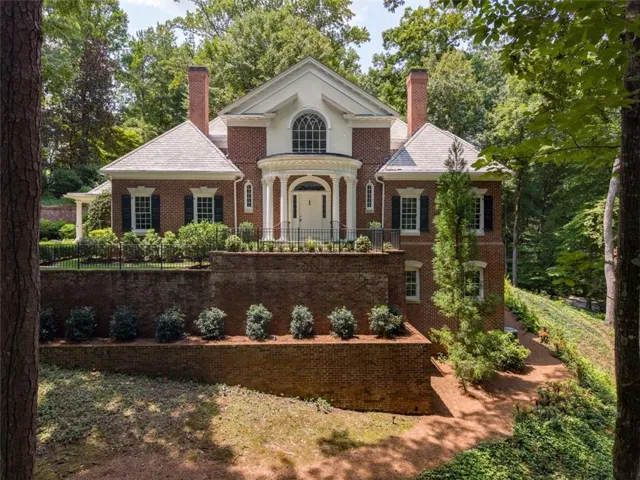 Brick exterior with white columned portico and a grand arched window