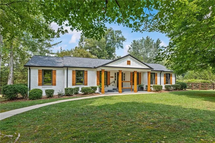 White brick exterior with dark shingle roofing