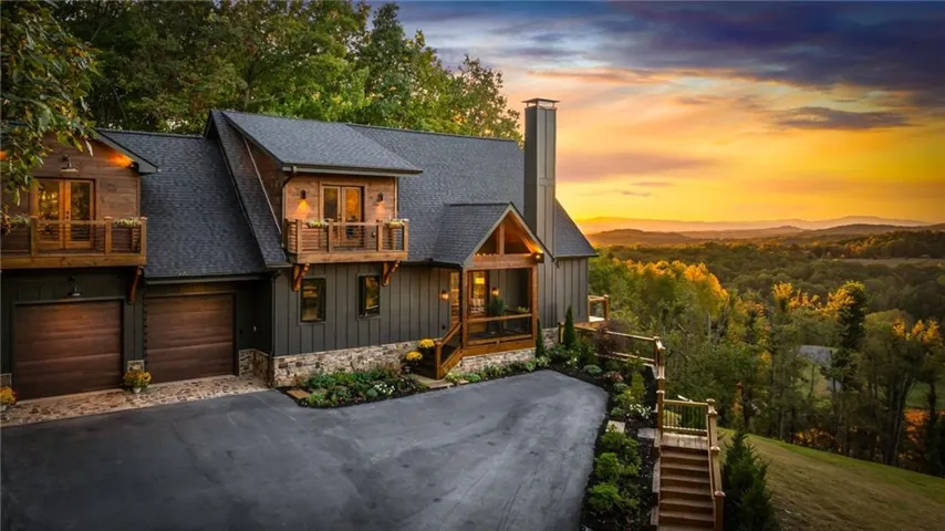 Wood-clad residential structure with multiple gables and a stone foundation