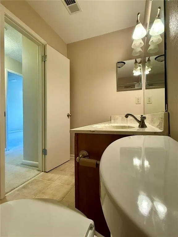 Bathroom with light tile patterned floors and vanity