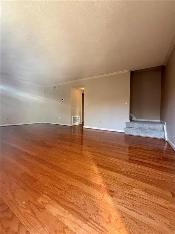 Spare room with light wood finished floors and a textured ceiling