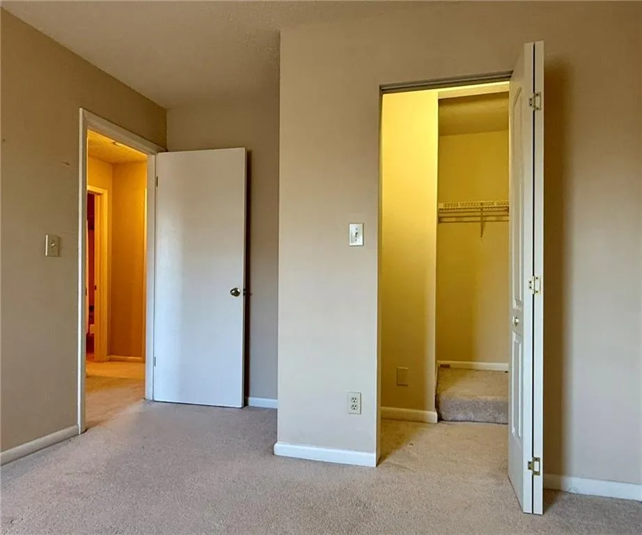 Unfurnished bedroom with a walk in closet and carpet flooring