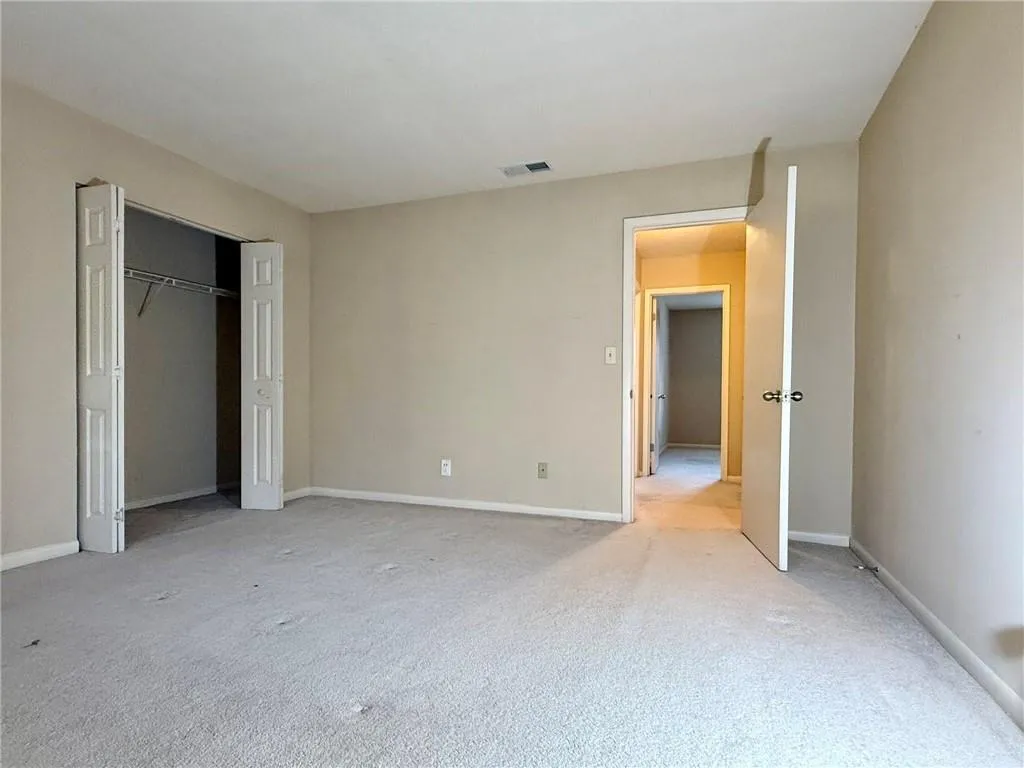 Unfurnished bedroom with carpet flooring and a closet