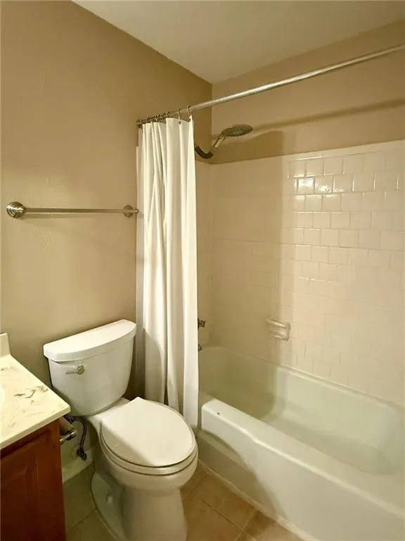 Bathroom with light tile patterned floors, vanity, and shower / bath combo