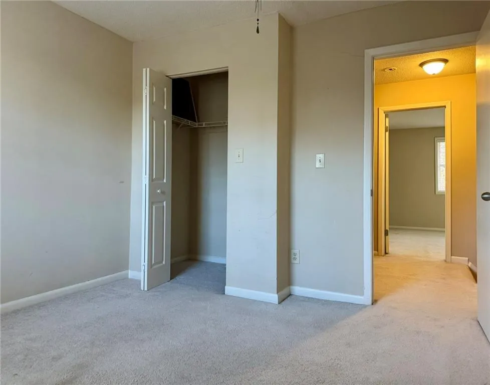 Unfurnished bedroom with light colored carpet and a closet