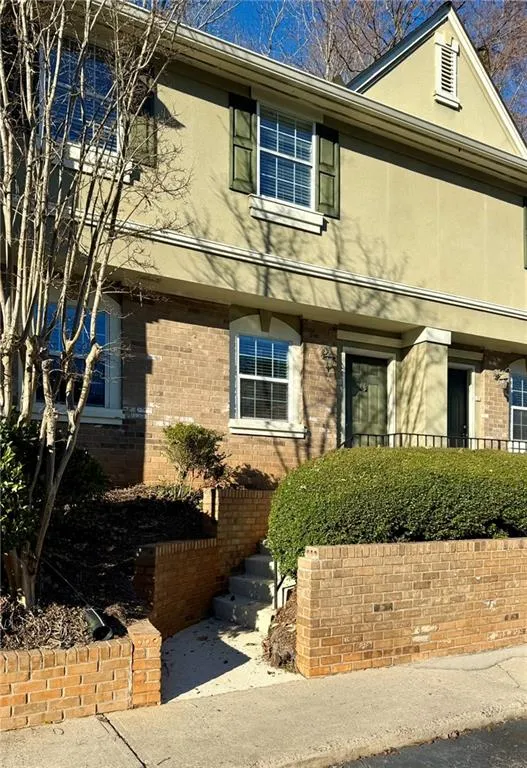View of front of property featuring stucco siding and brick siding